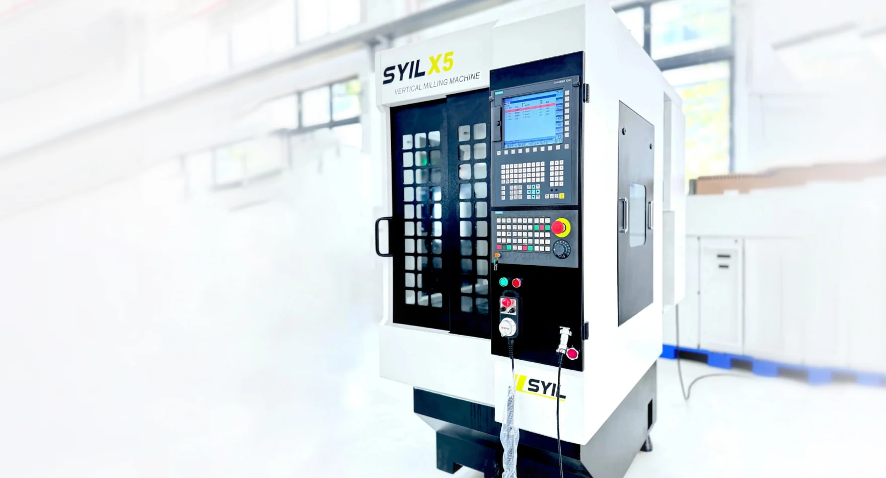 SYIL X5 w pełnej obudowie z automatycznym magazynem narzędzi. To przykład przejścia od otwartego routera lub frezarki do kompaktowego centrum pionowego. Fotografia producenta: SYIL — X5.
