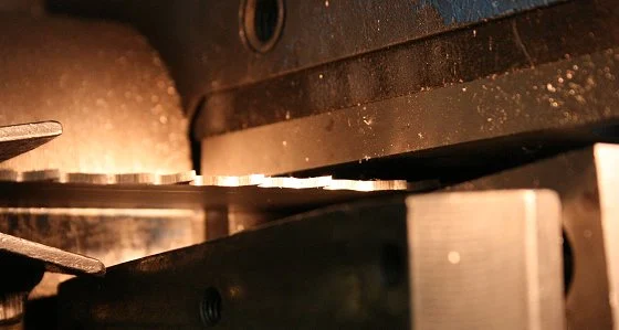 Mechaniczne nadawanie rozwiedzenia zębom w procesie produkcji taśmy. Kontrolowana sekwencja odchylenia tworzy szerokość rzazu i rozkład sił bocznych; dlatego rozwiedzenia nie powinno się poprawiać ręcznie na pętli produkcyjnej. Fotografia producenta: WIKUS — produkcja taśmy bimetalicznej.